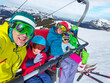© Sergey Novikov - Big smiling family is on ski lift, does selfie, mountains around