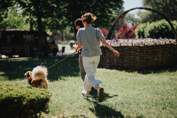 Poster - A happy young woman enjoys a sunny day at the park, running with her energetic dog, surrounded by green trees and grass.