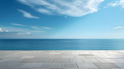 Wall Mural - A serene ocean view under a clear blue sky, seen from a spacious stone terrace with light clouds.