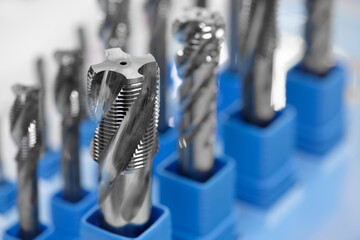Poster - A row of metal tools with blue plastic holders. The tools are all different sizes and shapes. Concept of organization and precision, as the tools are neatly arranged in their respective holders