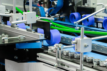Poster - Part of a modern roller conveyor with metal and plastic rollers for the production of various products, industrial concept background.