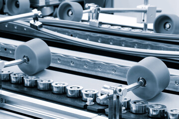Poster - Part of a modern roller conveyor with metal and plastic rollers for the production of various products, industrial concept background.