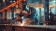 © Khalida - Metal worker wearing protective workwear while welding metal at a factory emphasizing industrial safety and manufacturing processes
