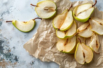 Wall Mural - Sweet dried pear chips on baking paper with fresh green pears on light table