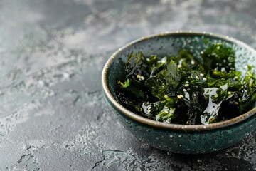 Poster - Traditional Japanese crispy nori seaweed sheets on green bowl against grey background a healthy close up snack