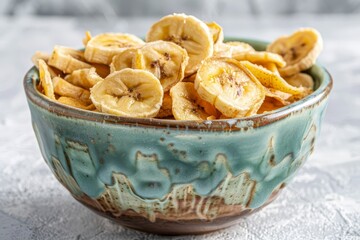 Poster - Banana chips in aqua ceramic bowl with white background