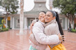 © Guillermo Spelucin - Lesbian couple hugging standing in the city in winter