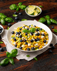 Wall Mural - Blueberry Corn Feta Salad in white plate on wooden table. Healthy food