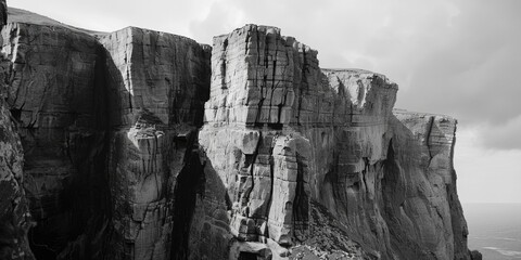 Poster - A black and white photograph of a rugged cliff face with texture and detail