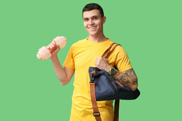 Sticker - Young man with sports bag and dumbbell on green background