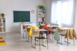 © Pixel-Shot - Blurred view of classroom with chalkboard, desks and shelf units