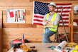 © Pixel-Shot - Male architect near USA flag in workshop. Labour Day celebration