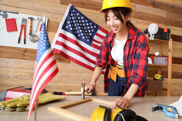 Sticker - Female Asian worker hammering frame in workshop. Labour Day celebration