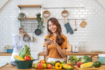 Wall Mural - Portrait happy beauty slim healthy asian woman use phone and vegan food healthy fresh vegetable and fruit in kitchen.diet, vegetarian, eating, fruit, wellness, health, green food.Fitness, healthy food