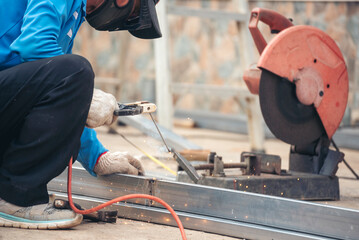 Wall Mural - Men hands wear protective glove Hot flame metal work cutting fire iron workshop. Locksmith use Welding machine cut metal process. Construction Worker hands using Welding machinery iron metal sparking