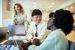 © Marko Geber - Multiethnic female colleagues discussing work with laptops in a modern office