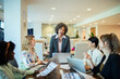 © Marko Geber - Multiethnic female colleagues discussing work with laptops in a modern office