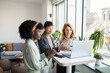© Marko Geber - Diverse young female colleagues with laptop in modern office