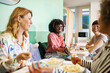 © Marko Geber - Diverse female employees eating lunch together in office
