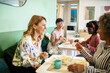 © Marko Geber - Diverse female employees eating lunch together in office