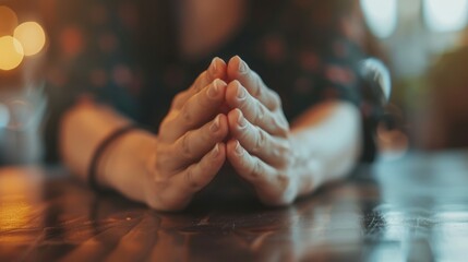 A woman is praying with her hands clasped together