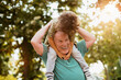 © Geber86 - Grandfather giving piggyback ride to grandson in sunny park