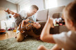 © Vorda Berge - Father playing with son while being photographed by daughter at home