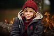 © Stocknterias - Portrait of a cute little boy in a red hat and coat in the autumn forest.