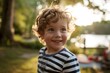 © Stocknterias - Portrait of a smiling little boy in a striped t-shirt in the park