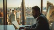 © evgenia_lo - A man in a suit is typing on a laptop in front of a window overlooking a city