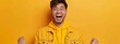 © Viktor - A man in a yellow jacket, mouth agape and hands raised against a solid yellow backdrop