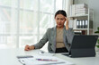 © crizzystudio - Asian woman, independent businesswoman, feeling stressed, achy, and sleepy while working on a laptop. Tired Asian businesswoman has a headache at the office Feeling sick at work.