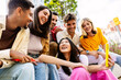 © Xavier Lorenzo - Happy group of young friends having fun using mobile phones at city street. Millennial generation people bonding while watching social media content on cell phone devices app. Youth and communication