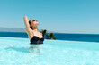 © Westend61 - Woman wearing sunglasses and relaxing in swimming pool on sunny day