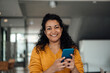 © Westend61 - Happy businesswoman holding smart phone at office