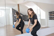 © mitarart - Woman In A Fitness Studio Performing An Exercise With A Blue Ball, Reflected In A Large Mirror