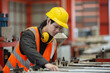 © eakgrungenerd - Asian male workers wear red helmet working check up iron production manufacturing in factory. Foreman in heavy Industrial workplace.