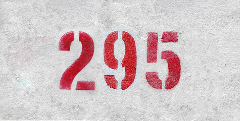 Red Number 295 on the white wall. Spray paint.