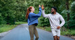 © DusanJelicic - Diverse friends giving a high five during their run in the park, smiling and enjoying their workout together. Dressed in sportswear, they celebrate their fitness journey.