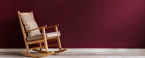 Wall Mural - A traditional beech wood rocking chair with cushioned seat, placed against a burgundy luxury house wall.