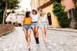 © Xavier Lorenzo - Happy multiracial women having fun together on summer vacation. Female friends hugging each other while walking in town. Holiday lifestyle concept.