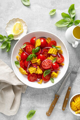 Canvas Print - Tomato and corn salad with fresh basil, onion, dressed with olive oil. Mexican food, tomato corn salad Esquites, top view