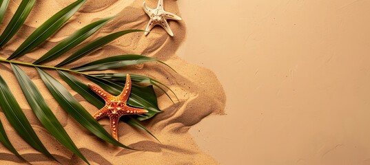 Wall Mural - Top view of a starfish and a tropical leaf on a sand-colored background.