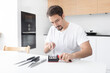 © Vitaliy - Close-up photo of man sharpening knives with special knife sharpener at home