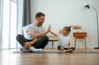 © standret - Father with little daughter are doing yoga at home
