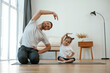 © standret - Spine exercise. Father with little daughter are doing yoga at home