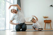 © standret - Front view, together. Father with little daughter are doing yoga at home