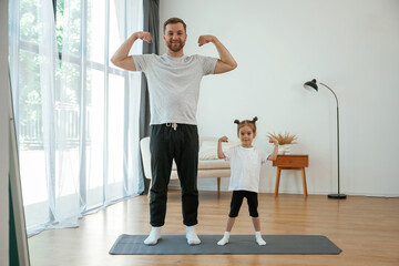 Sticker - Front view, together. Father with little daughter are doing yoga at home