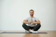 © standret - Yoga man is sitting on a mat at home