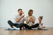 © standret - With apples in hands. Family of mother, father and daughter are doing yoga at home